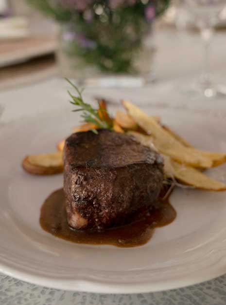 Fotografía de un plato de solomillo de ternera con patatas para un evento